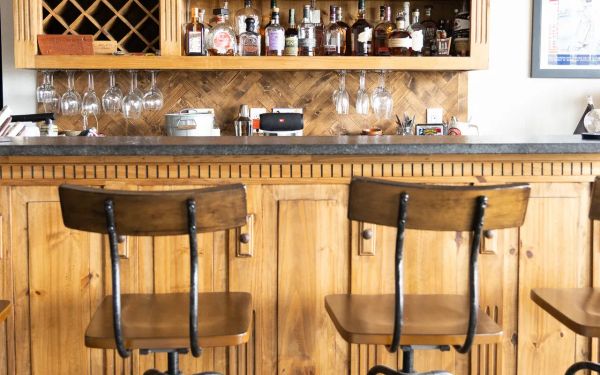 Finished basement bar with wood stools in an Open Prairie custom home