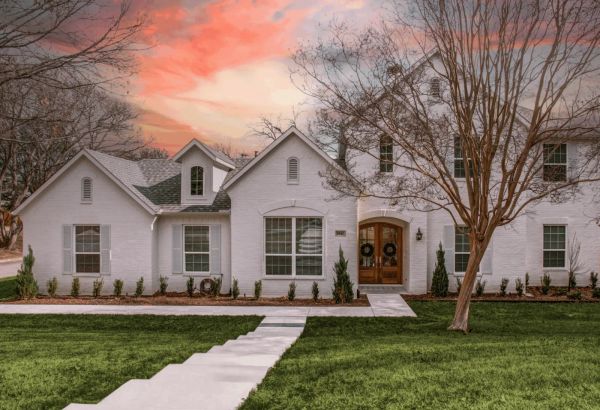 White brick custom home at dusk built by Open Prairie in Parker County