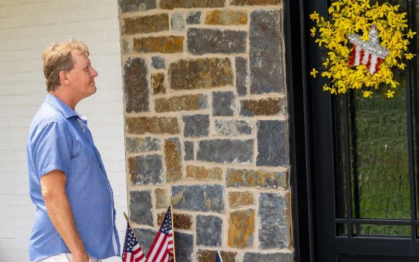 Dan Schlaak inspecting the stone facade of a custom home under construction