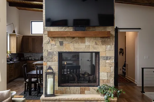 Stone Fireplace Barn Door — custom home by Open Prairie (The Estate · Graford)